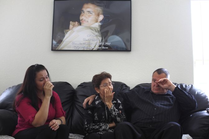 A picture of Daniel Adkins Jr. hangs above the wall in his family home. His sister, Marina Reyes; mother, Antonia Adkins; and father, Daniel Adkins Sr., want the man who shot their son to face charges.