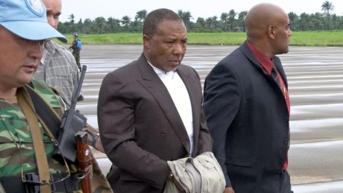 Liberian ex-President Charles Taylor is escorted at the Freetown, Sierra Leone, airport on his way to the Netherlands in 2006.