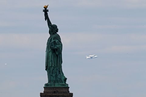 The Enterprise passes the Statue of Liberty into New York on the last leg of its final flight Friday.