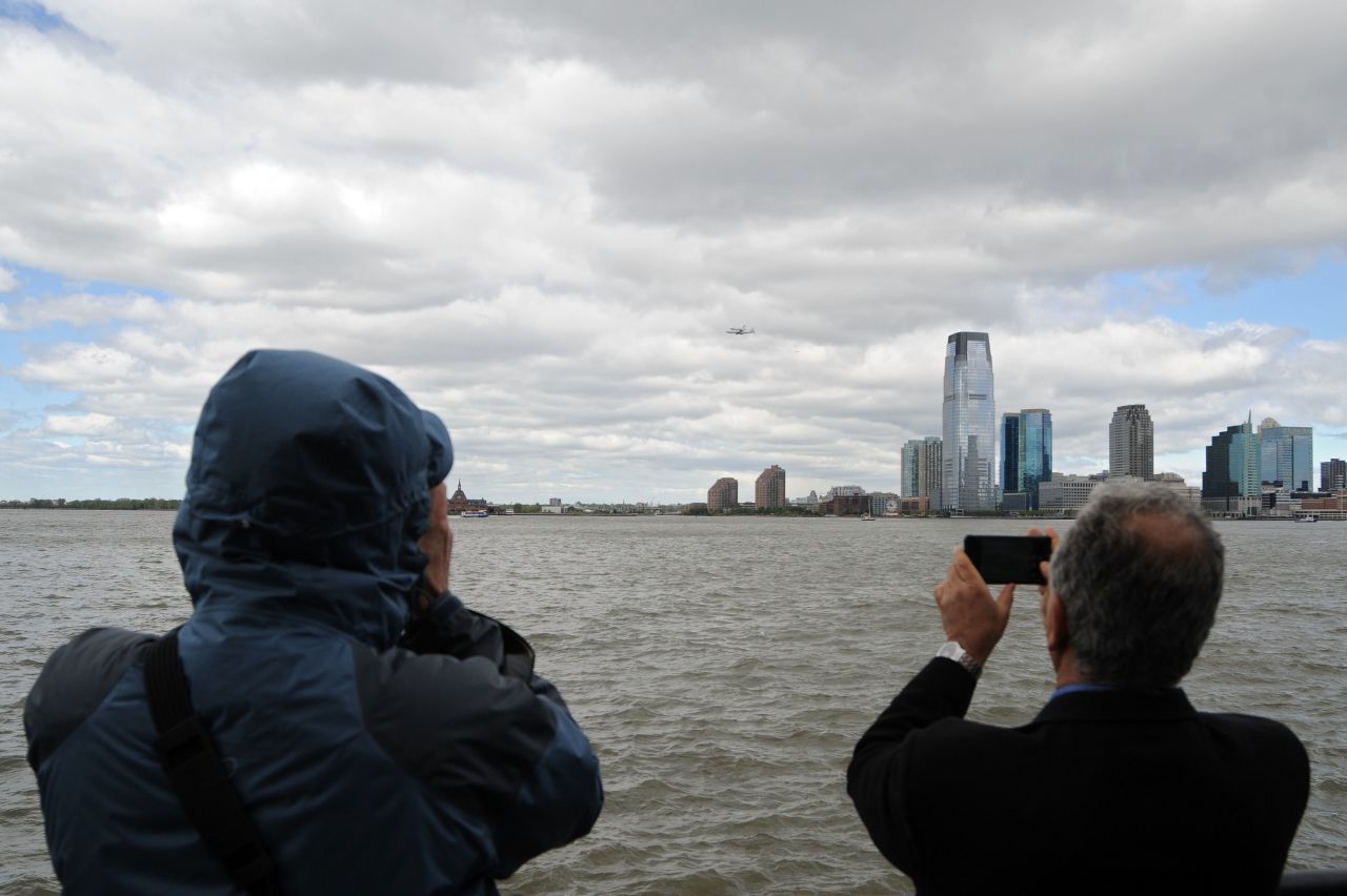 People photograph the Enterprise as it flies by the New Jersey skyline Friday. 