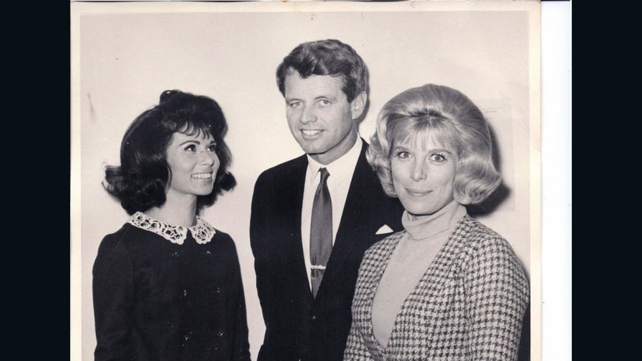 In this NBC photo taken in December 1965, TV actress Nina Roman, today known as Nina Rhodes-Hughes, left, and her "Morning Star" co-star Elizabeth Perry, right, meet Robert F. Kennedy at NBC's Burbank studios. Two and a half years later, Rhodes-Hughes witnessed Kennedy's assassination.
