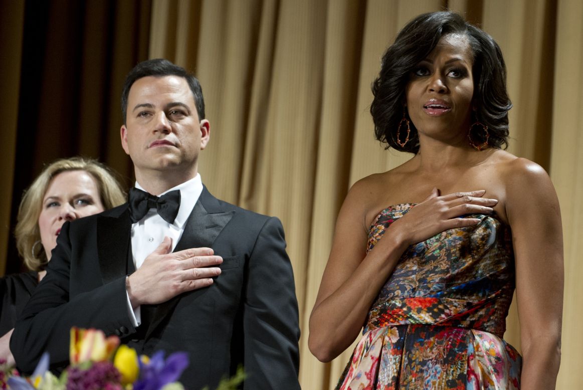 Host Jimmy Kimmel stands alongside first lady Michelle Obama while the national anthem is played.