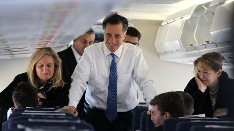 Mitt Romney and his wife Ann Romney talk to members of his staff aboard his campaign plane in March.