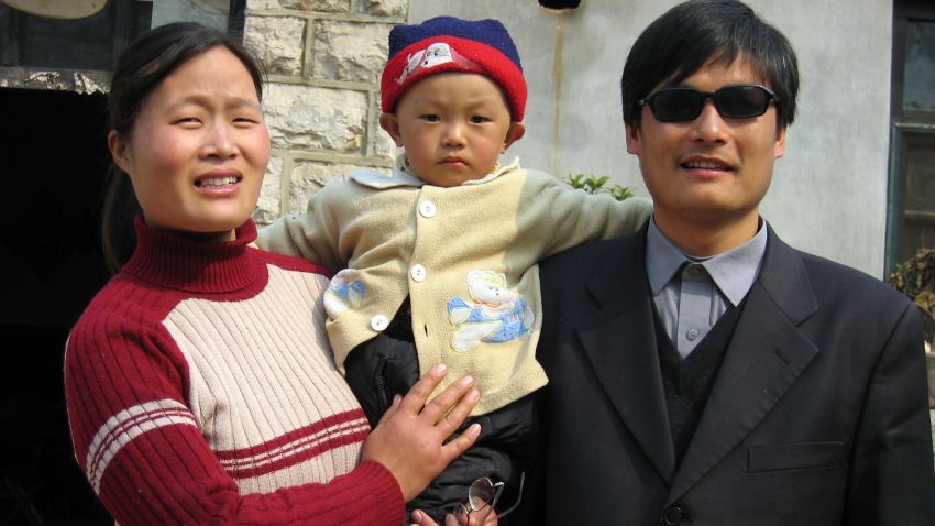 A picture dated March 28, 2005 shows blind activist Chen Guangcheng (R) with his wife and son Chen Kerui outside the home in Dondshigu village, northeast China's Shandong province. Chen, who gained worldwide fame for exposing abuses in China's 'one child' population policy, was freed on September 9, 2010, after four years in prison for accusing family-planning officials in eastern China's Shandong province of forcing at least 7,000 women to be sterilised or undergo late-term abortions. CHINA OUT AFP PHOTO (Photo credit should read STR/AFP/Getty Images) 