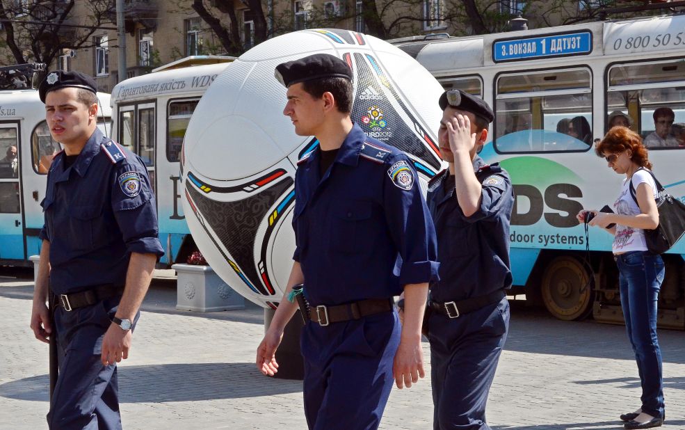 Police officers walk past a giant model of "Tango 12," the official match ball of the Euro 2012 football tournament, during a patrol in Dnipropetrovsk on April 29. No group has yet claimed responsibility for the bomb attacks. 