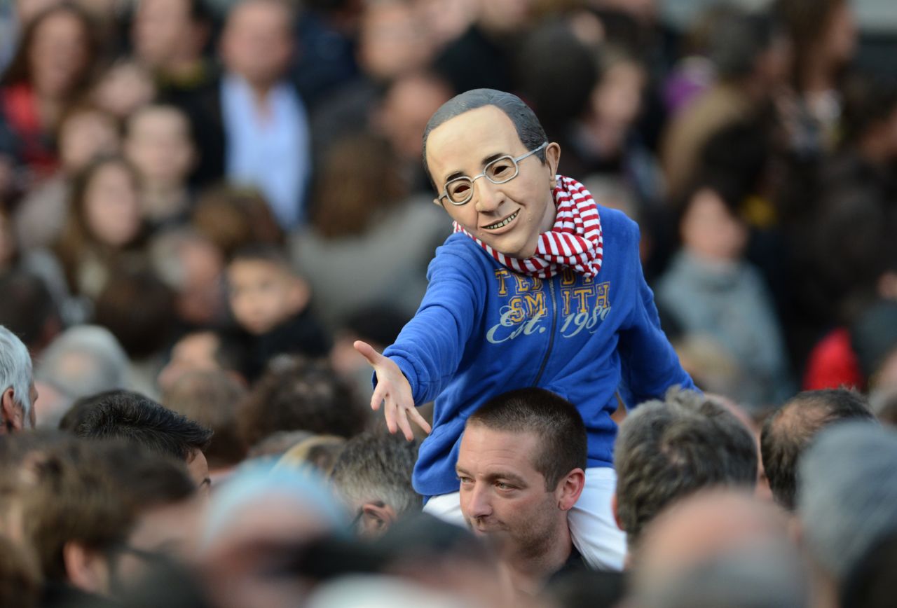 A boy wearing a mask resembling Francois Hollande gestures before the politician's speech Sunday.