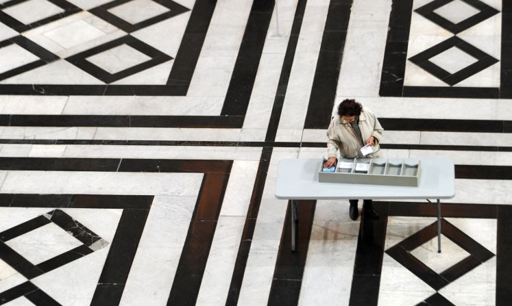 A woman picks up ballots before voting at a polling station in Marseille, France, on Sunday.