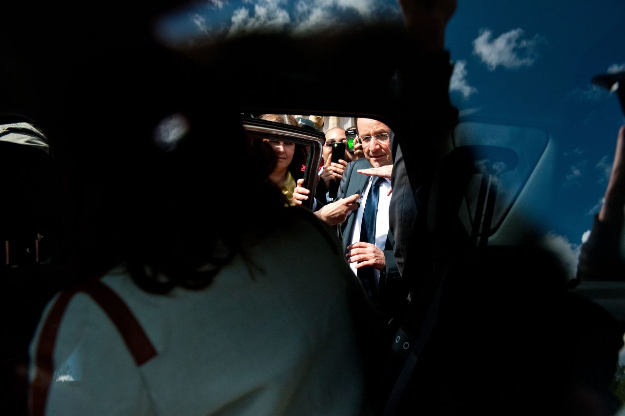 Francois Hollande squeezes past members of the public to get into a car Sunday during a visit to Vigeois, in central France.