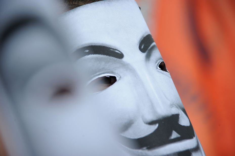 A protester wears a Guy Fawkes mask Sunday.