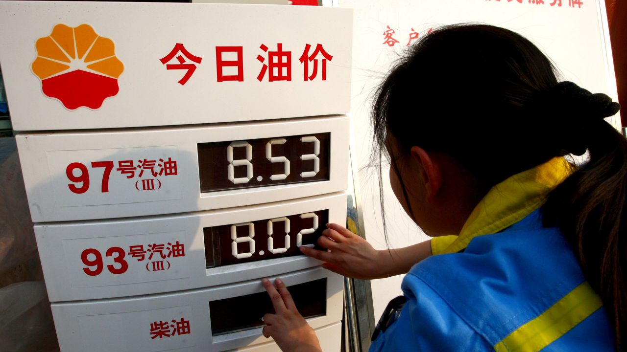 A worker changes the price panel at a petrol station in Suining, southwest China's Sichuan province on March 27, 2012. 