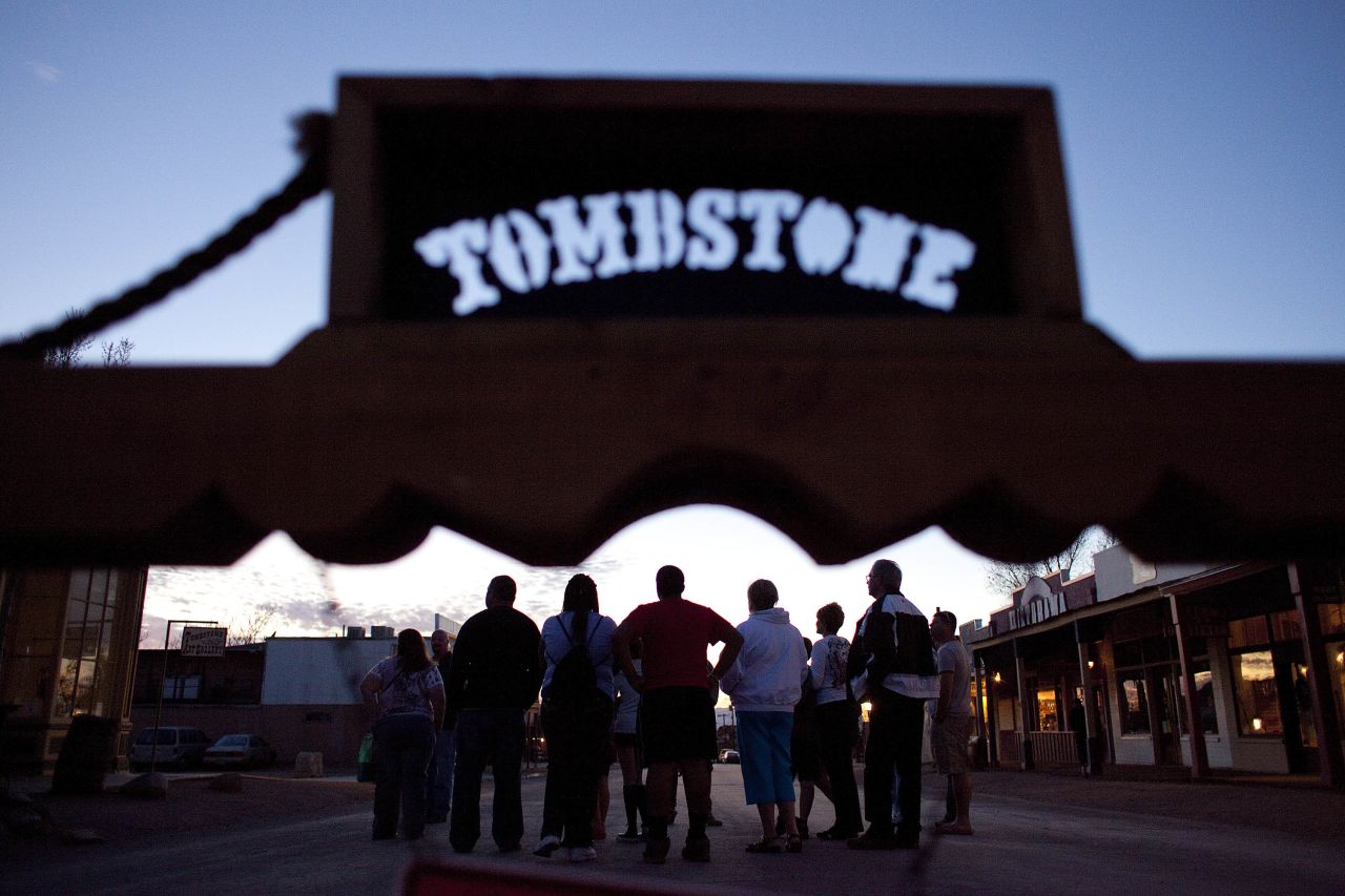 A tour group meets at sunset in downtown Tombstone, which receives as many as half a million visitors each year. 