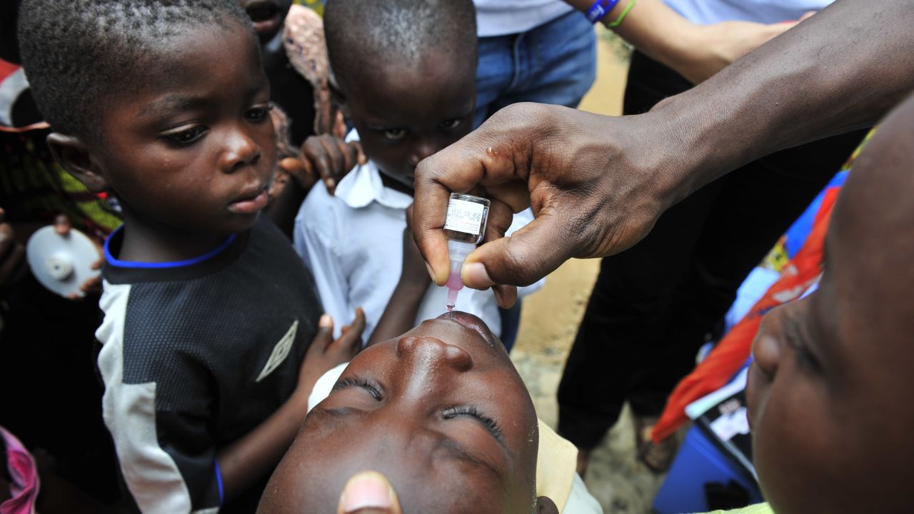 A child receives an oral polio vaccine in Ivory Coast. Improved vaccines are helping save children's lives globally.