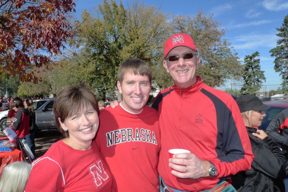 Brett Major, center, with his parents, is a gay Christian Nebraska fan who once revered Brown.  