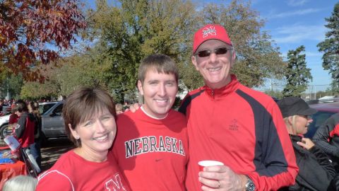 Brett Major, center, with his parents, is a gay Christian Nebraska fan who once revered Brown.