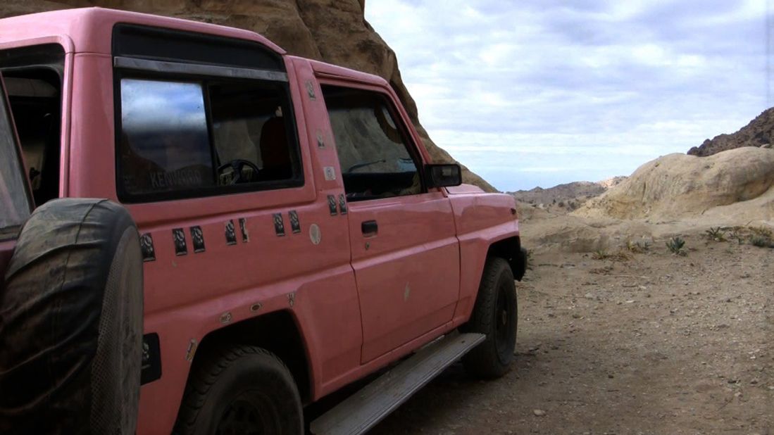 Al-Bedoul's bright pink jeep, "the couch surfing flag," is parked outside.