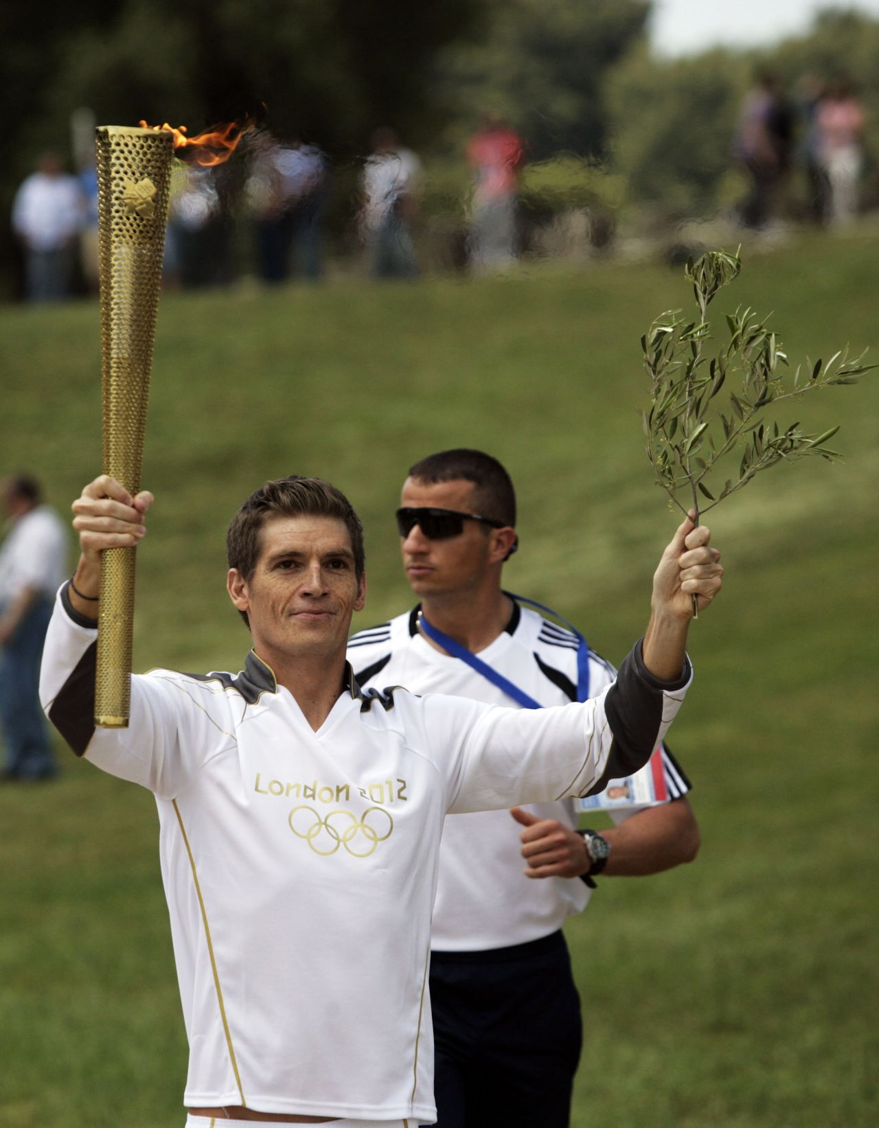 More than 8,000 torch-bearers will carry the flame before it arrives at the Olympic Stadium in east London on July 27. The first was Greek swimming champion Spyros Gianniotis.
