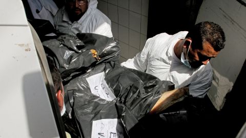 At a morgue in Mexico, forensic technicians unload some of the dismembered bodies that were found alongside a highway.
