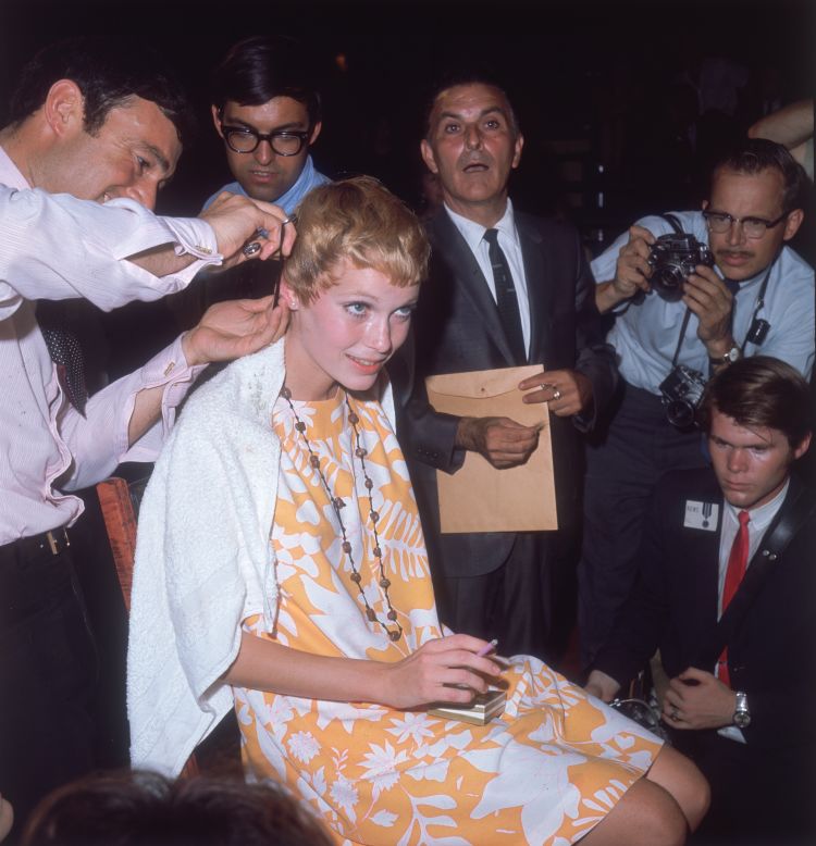 American actress Mia Farrow gets her hair cut short by Vidal Sassoon in 1967 while surrounded by photographers. Her famous pixie haircut was featured in the 1968 horror film Rosemary's Baby. 