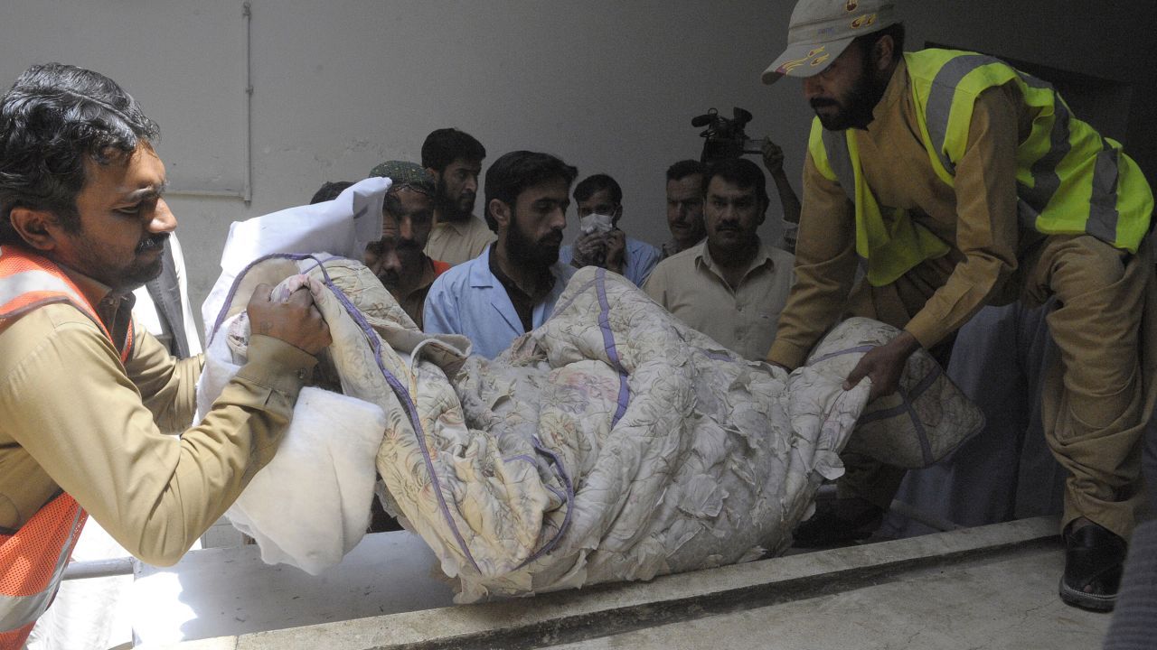 Pakistani volunteers carry the body of British aid worker Khalil Rasjed Dale at a hospital in Quetta on April 29.
