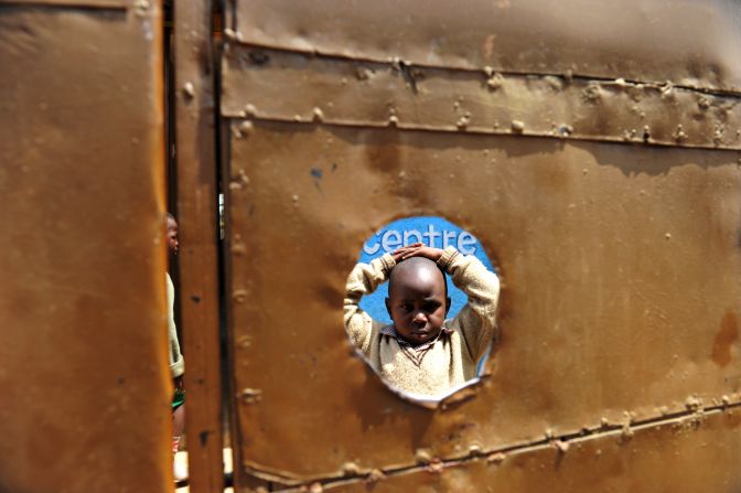 According to the WHO, every 90 seconds a woman dies from a pregnancy-related complication somewhere in the world leaving children to grow up with out their mother. Here five-year-old Peter Otieno stands in the inside courtyard of the preschool he attends in Kenya. Peter is HIV positive and became infected after his mother gave birth to him. Both his father and his mother have passed away.