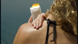sunscreen application woman beach swimsuit