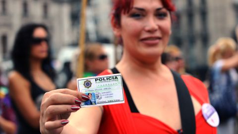 Walter Daniel Alvarez shows his police credential whilst waiting outside Congress in Buenos Aires, on May 9, 2012. 