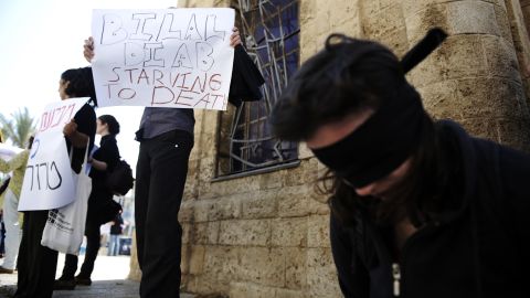 A blindfolded woman and demonstrators with posters show solidarity with prisoner Bilal Diab in Jaffa on Saturday.