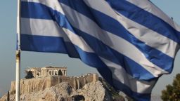 The Greek flag flies in front of the Acropolis