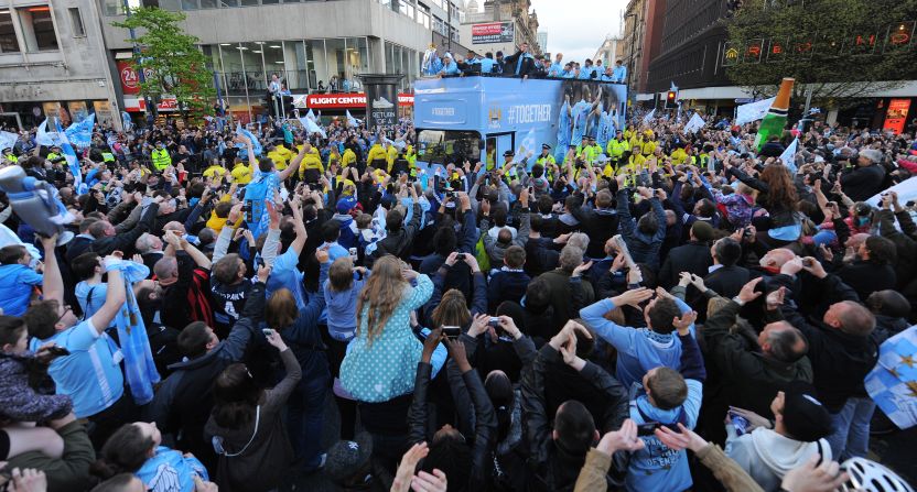 Thousands of supporters crammed the route as the City team paraded the cup on an open top bus through the Manchester city center.