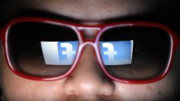 A logo of social networking facebook is reflected on the spectacles of a student browsing the website in Manila on May 14, 2012. Facebook may be the year's hottest stock issue -- but try getting a piece of it. Small investors will find the line long and hurdles high to get even a handful of shares.  AFP PHOTO/TED ALJIBE        (Photo credit should read TED ALJIBE/AFP/GettyImages)