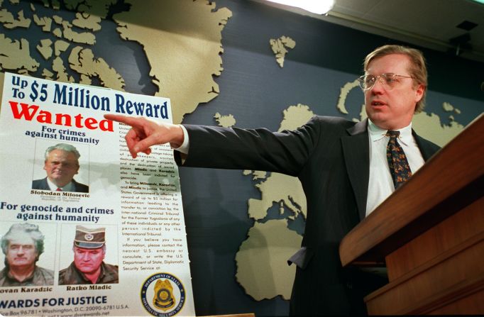 David Scheffer, U.S. Ambassador at large for war crimes points to a wanted poster showing Yugoslav President Slobodan Milosevic, Karadzic and Mladic in March 2000.