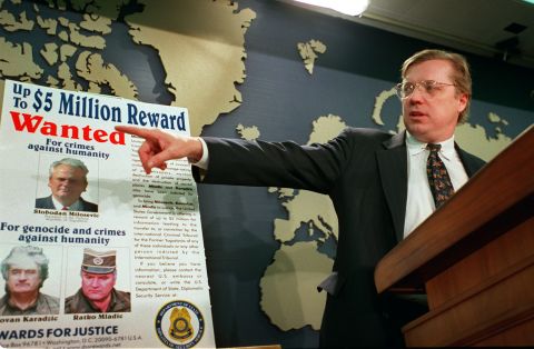 David Scheffer, U.S. Ambassador at large for war crimes points to a wanted poster showing Yugoslav President Slobodan Milosevic,  Karadzic and Mladic in March 2000.