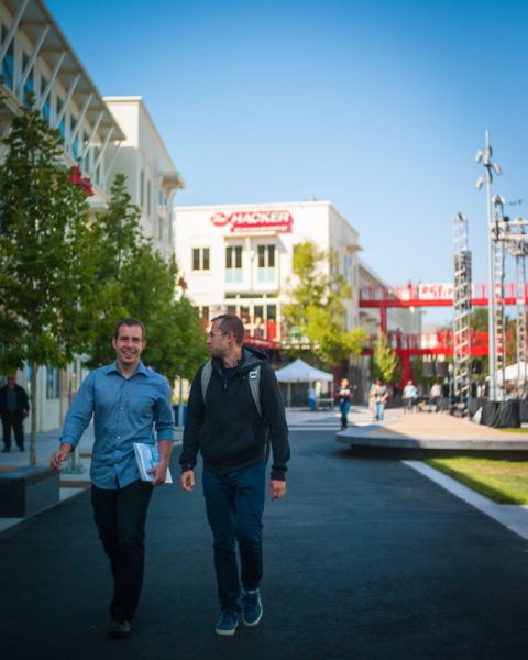Facebook team members walk across the company's sprawling new campus on their way to Thursday night's Hackathon kickoff event. 