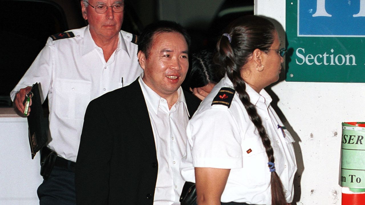 Chinese businessman Lai Changxing is escorted by security guards into a Vancouver federal courthouse on July 12, 2001. 