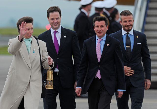 Britain's Princess Anne, from left, Deputy Prime Minister Nick Clegg, 2012 Chairman Lord Sebastian Coe and former England footballer David Beckham, right, cross the tarmack with the Olympic flame lantern.
