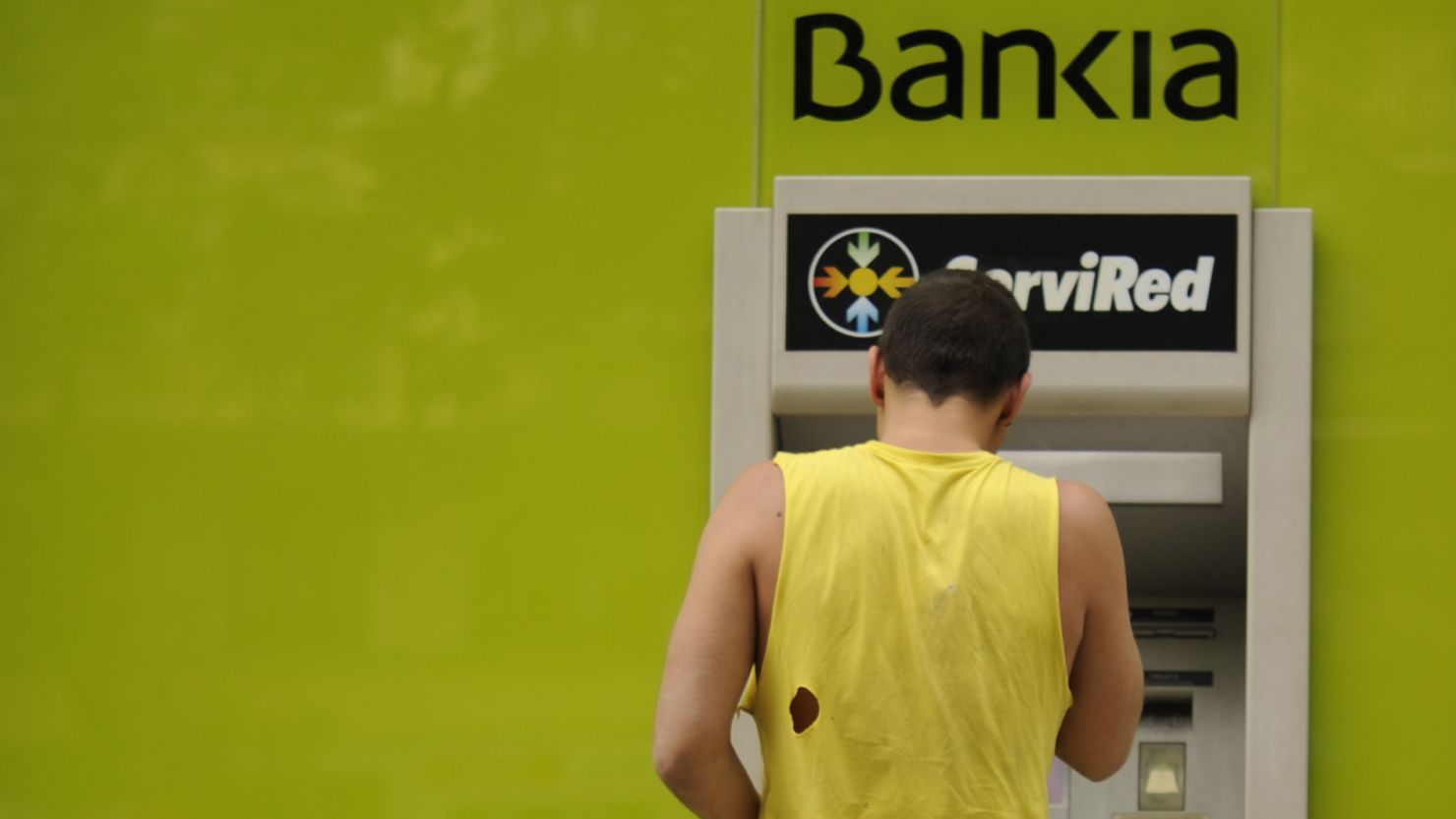 A man uses a Bankia ATM machine in Madrid, Spain.