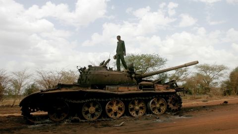 A Sudanese soldier stands atop a destroyed tank for Sudan People's Liberation Army of South Sudan in Heglig on April 23, 2012.