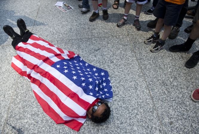 An Occupy Wall Street protester in Chicago covers himself with an American flag after a march through downtown Chicago on Friday.