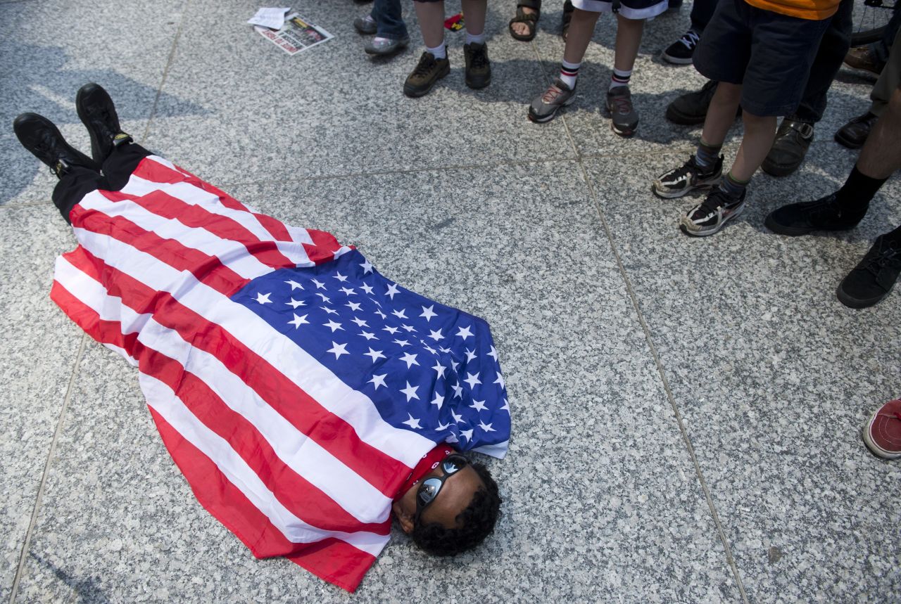 An Occupy Wall Street protester in Chicago covers himself with an American flag after a march through downtown Chicago on Friday.