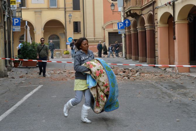 A woman carries a blanket on a blocked street following the quake in San Felice sul Panaro, Italy.