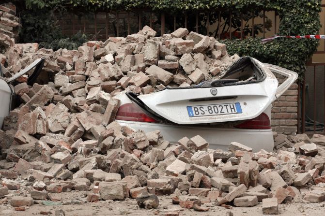 Cars are left buried under rubble from Sunday's earthquake in Finale Emilia. 