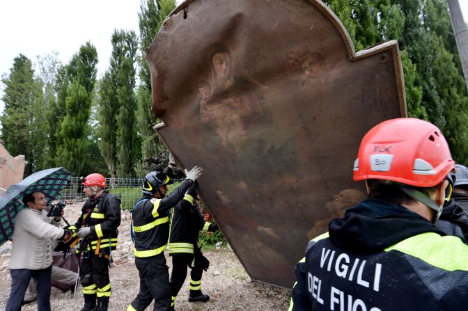 Firefighters recover a painting from a church that was destroyed by the quake in the village of San Carlo, Italy.