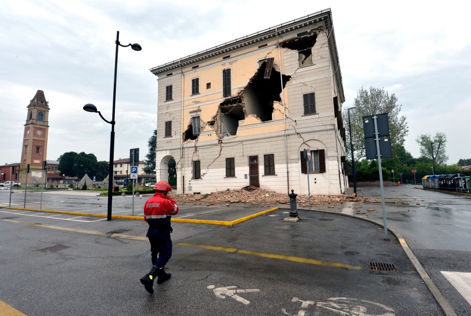 A rescuer walks near the town hall in Sant'Agostino village after a powerful earthquake shook Italy's industrial and densely populated Northeast early on Sunday, May 20. 