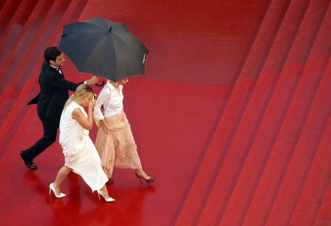 Guests arrive at Cannes during heavy rain on Sunday.