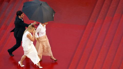 Guests arrive at Cannes during heavy rain on Sunday.