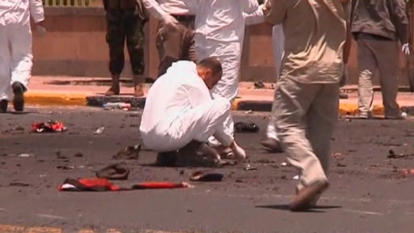 A forensic team member examines debris after a suicide bomber blow himself up at a military parade rehearsal in Sanaa, Yemen.