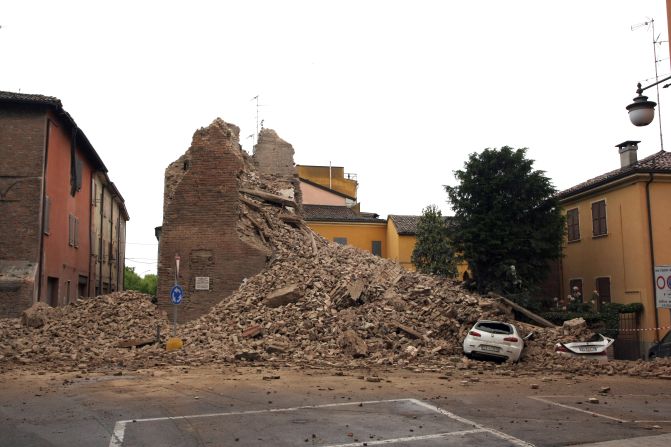 Rubble from the clock tower buries a car under its bricks.