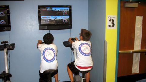 Students at an elementary school in Miami, Flordia, compete in an exer-game on stationary bikes.