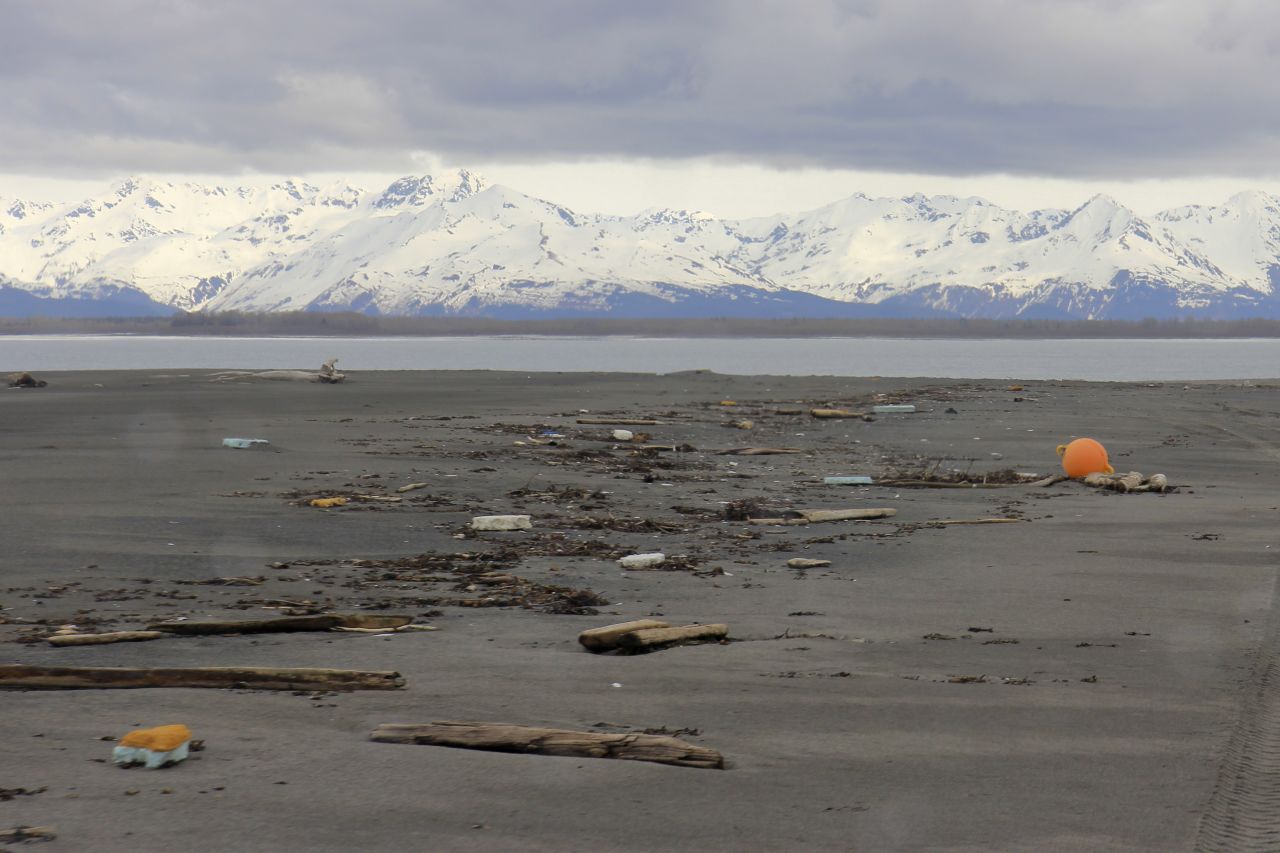 Debris litters a stunning remote beach on the Alaskan coast called Black Sand Spit at the mouth of the Dangerous River near Yakutat.