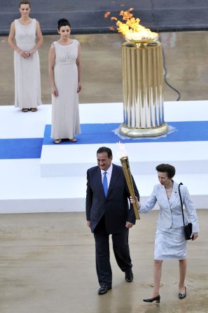 Queen Elizabeth II's daughter, Anne, the Princess Royal, receives the flame from Olympic chief Spiros Kapralos at a handover cermony in Athens on May 17.